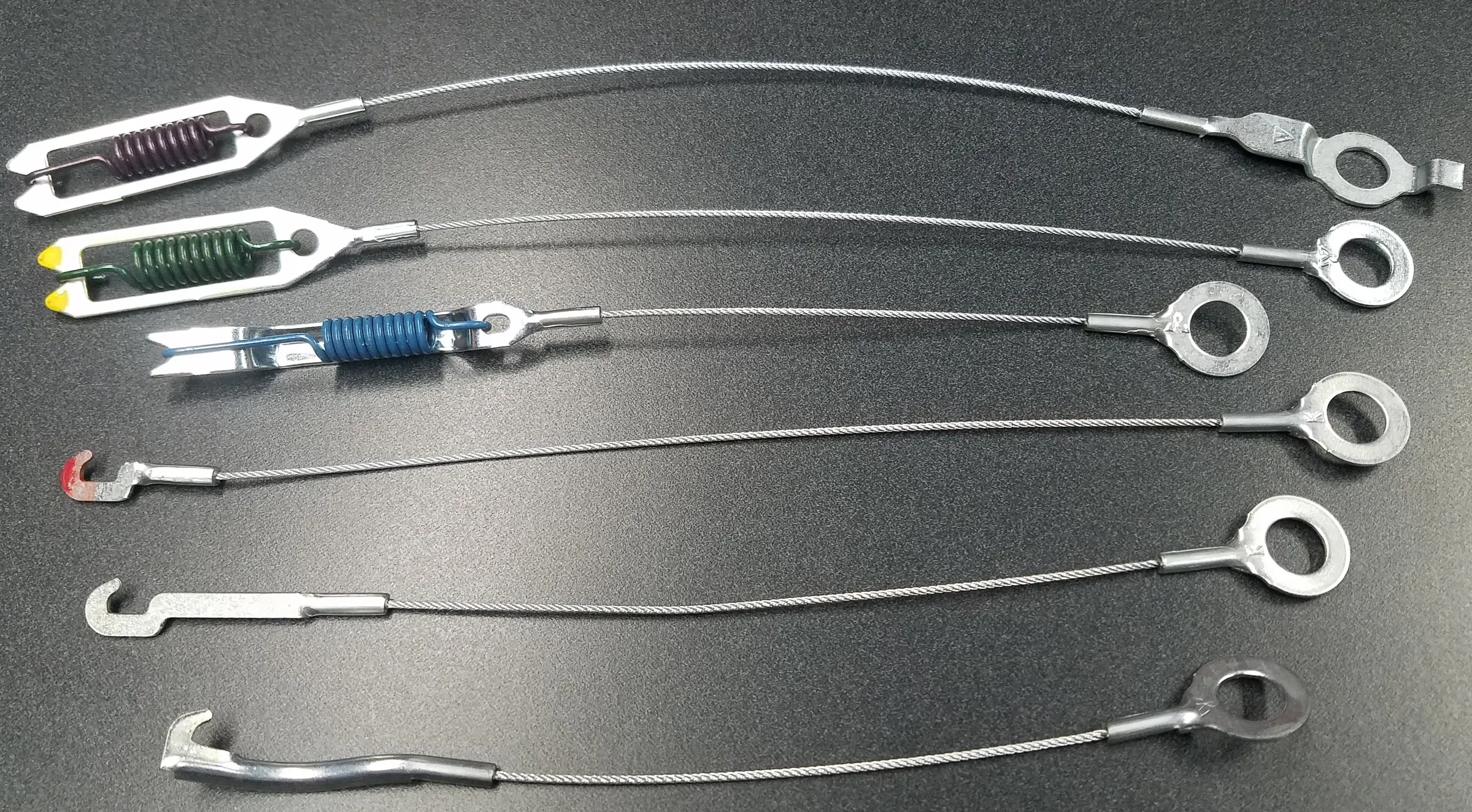 Collection of Kaufman brake cable assemblies showing different terminal types and colored springs